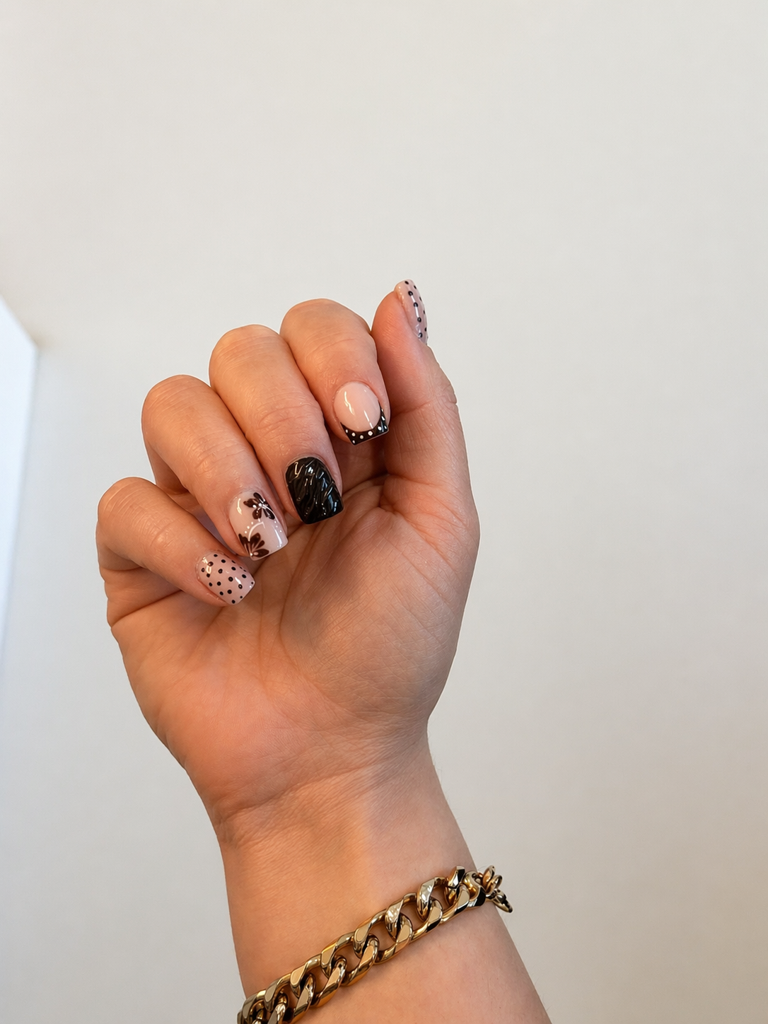 Nude nails with black polka-dot and floral art