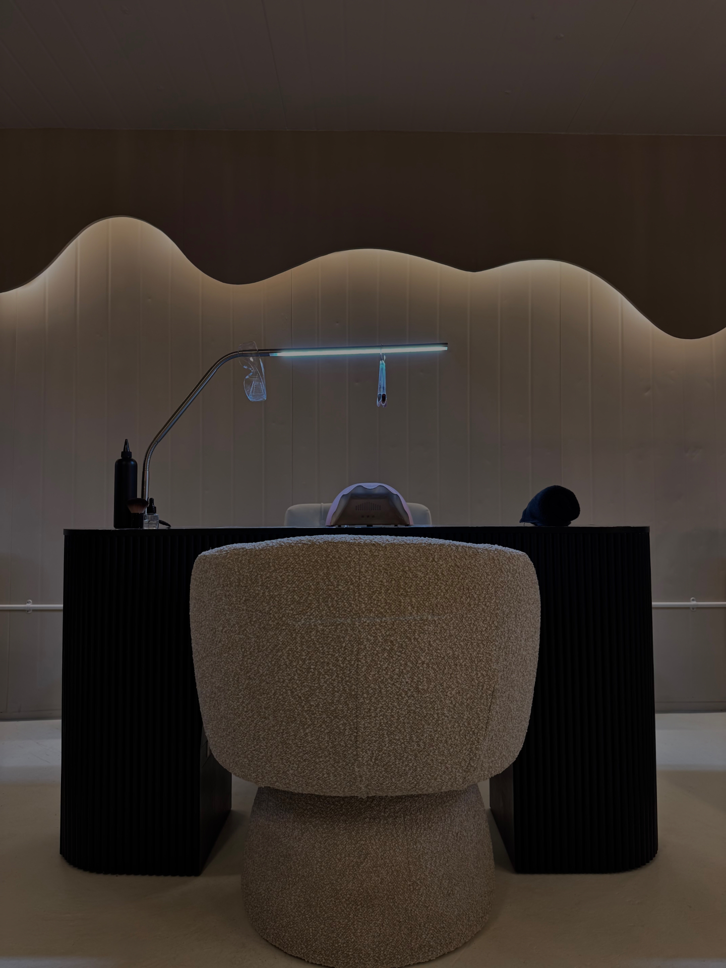 A luxury nail training desk with professional gel products and an open training manual in soft natural light